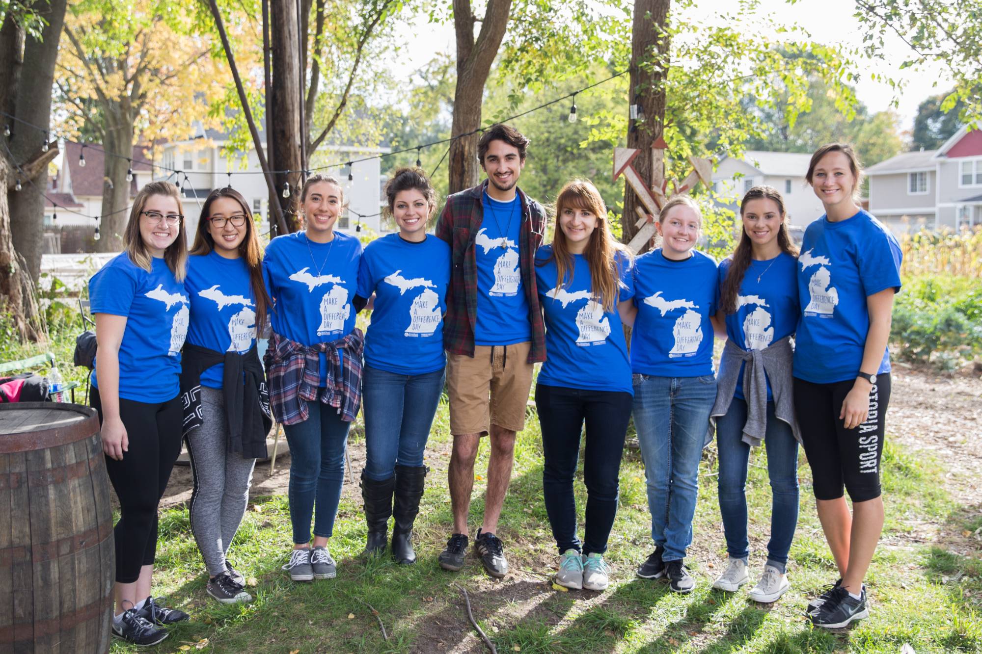 Group of nine students posing for a photo outside on a farm wearing blue Make A Difference Day t-shirts